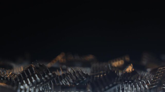 Vertical macro of TTL integrated circuits rotating on turntable, side view, yellow keylight, cold backlight, bokeh and shallow DOF. Black copy space on top third for text or graphic elements