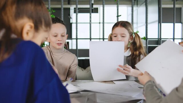 Group of children working together on art projects in a bright study area during the afternoon hours