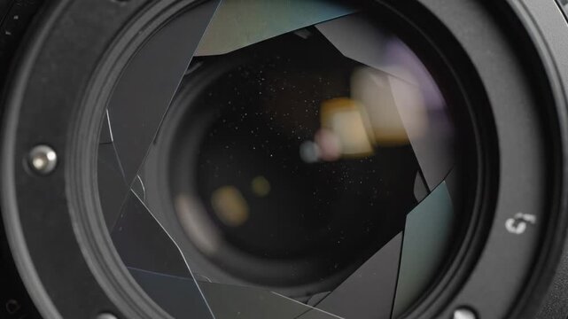 Close-up of camera lens aperture blades opening and closing with bokeh effects
