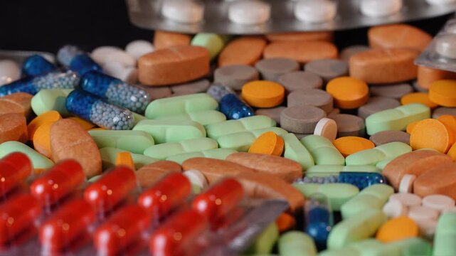 Side view of rotating medical pills and blister packs with beautiful bokeh and shallow DOF. Macro shot of pharmaceutical tablets on turntable ver 1