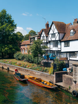 View of punts glide gently along the tranquil river, reflecting the charming Tudor architecture under the azure sky, Canterbury, England, United Kingdom.