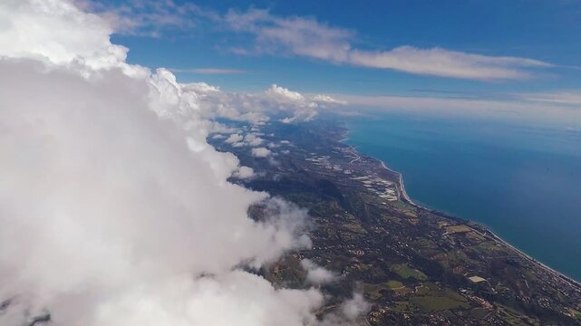 Aerial view of the California coast at Carpinteria while flying eastbound alongside a wall of towering cumulous clouds over the Santa Ynez mountains.