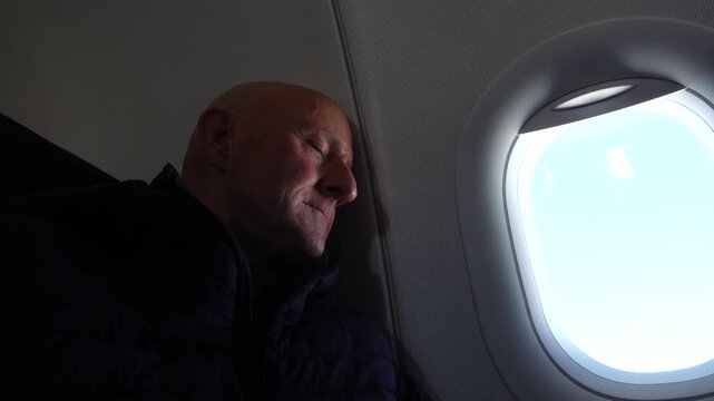 Stockholm, Sweden A man sleeping on a passenger airplane against the bulkhead,. 