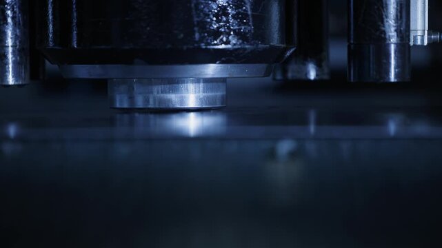 Slow motion metal press head pressing sheet metal on factory production line in industrial workshop..