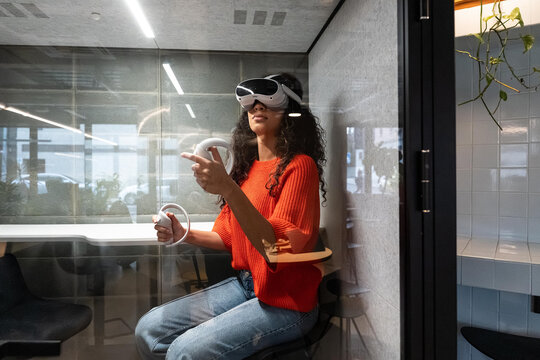 Woman using VR headset in modern office booth