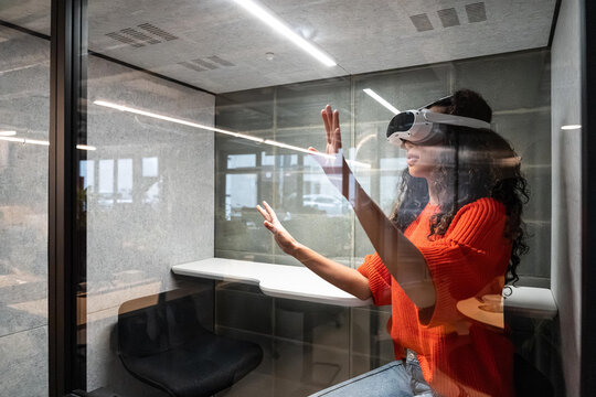 Woman using virtual reality headset in modern office