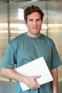 Confident professional man with laptop in modern office