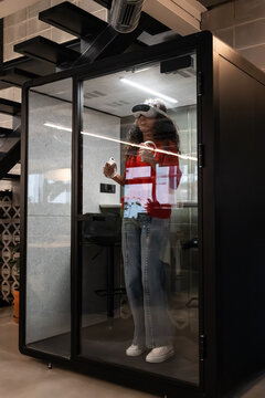 Woman exploring virtual reality in a modern office booth