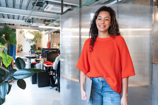 Confident woman standing in open coworking office