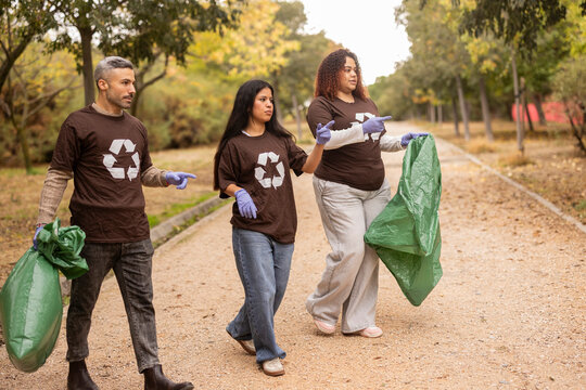 Multiethnic group picking up litter in park