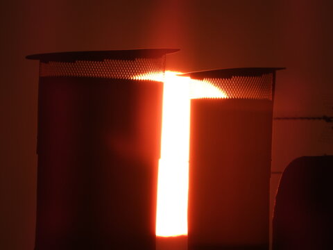 Dramatic close-up of a massive orange sun rising on the horizon, captured with a super telephoto lens