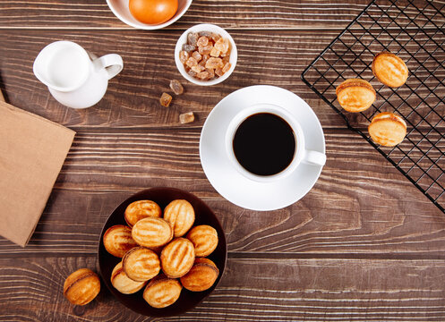 Cup of coffee with oreshki cookies and sugar cubes