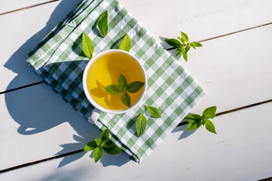 Refreshing homegrown mint tea on checkered cloth