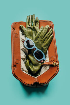 Fashion accessories in a leather handbag with sunglasses