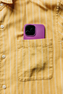 Smartphone in striped yellow shirt pocket closeup