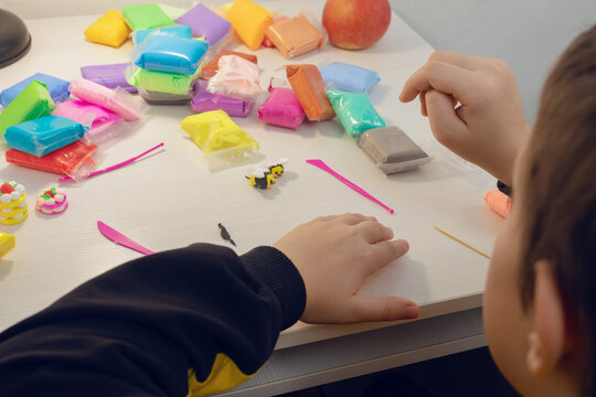 Child crafting with colorful modeling clay on table
