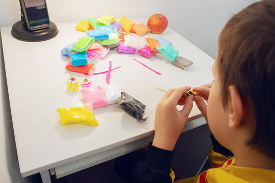 Child crafting with colorful modeling clay at home