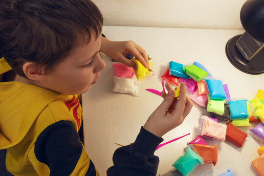 Child creating with colorful modeling clay indoors