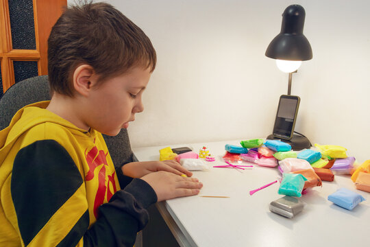 Child creating with colorful modeling clay at desk