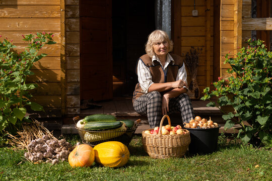 Woman sitting with harvest of fruits and vegetables