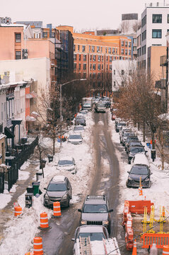 Urban winter scene with snow-covered streets and cars
