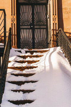 Snow-covered stairs leading to a doorway after a winter storm