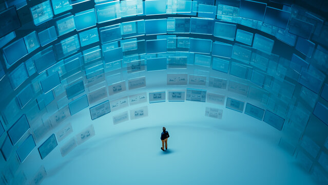 Silhouette of man observing multiple digital screens with graphics