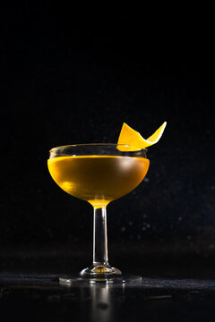 Elegant cocktail with lemon garnish on dark background