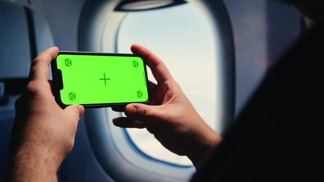 Man tourist using smartphone with green screen while traveling by train or bus, travelling application, male working during business travel. 