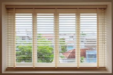 Fototapeta premium Window with blinds overlooking a residential scene on a bright day