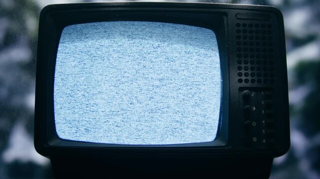 Retro TV, vintage television In a nostalgic setup, a retro TV displays grain on screen, scary halloween night device good for chroma key and green screen.