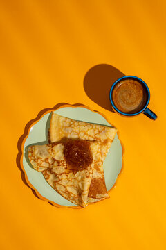 Breakfast crepes and coffee on bright surface