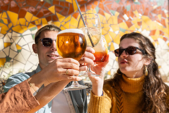 Friends toasting with drinks at an outdoor tapas bar
