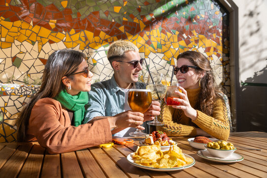Friends enjoying tapas and drinks outdoors
