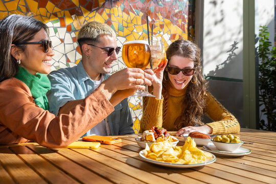 Friends enjoying tapas and drinks in the sun