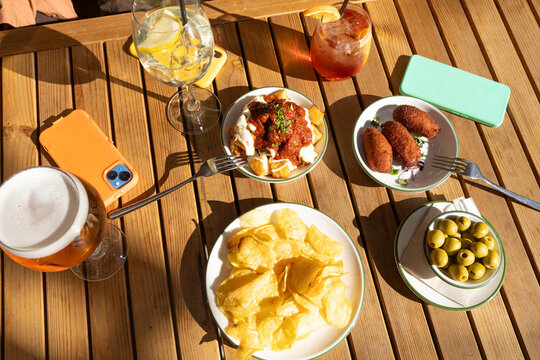 Tapas and drinks on a rustic wooden table setting