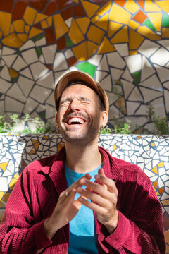 Man laughing joyfully in colorful mosaic setting