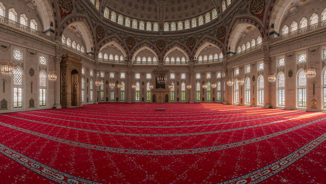 Grand interior of a mosque with ornate architecture and a vast red carpet