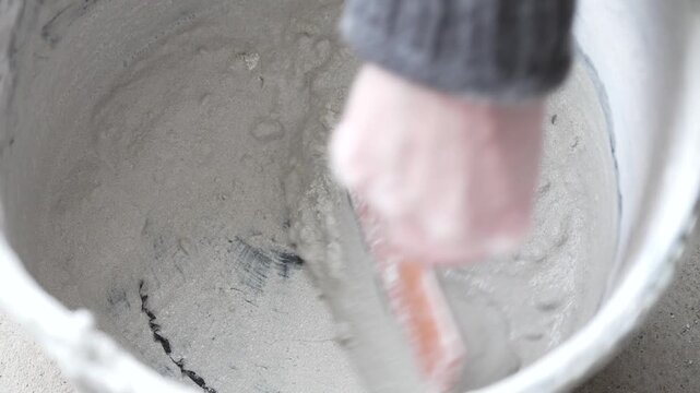 Mixing construction putty in plastic bucket with metal spatula making sharp squeaky sound, ASMR
