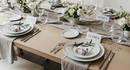 Fototapeta premium Elegant wedding table setting with white flowers and gift boxes for guest. Decorative banquet arrangement with porcelain plates, glassware and name cards on wooden table at reception.