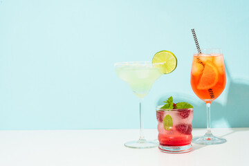 Margarita, Aperol Spritz and strawberry mojito at blue background.
