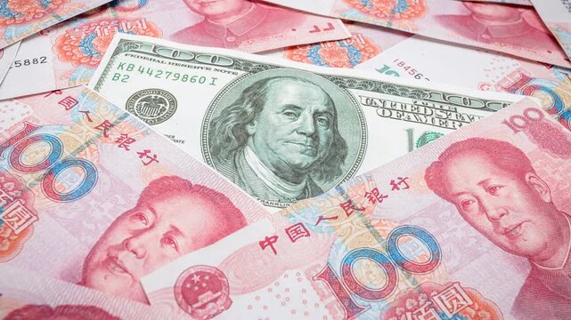 Background of Chinese yuan banknotes with US dollar bill in focus. Concept of economic power, currency exchange, global trade relations, and financial markets, Yuan banknotes surrounding a dollar bank