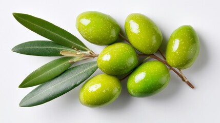 Obraz premium Green olives with leaves sit on white, seen from above.