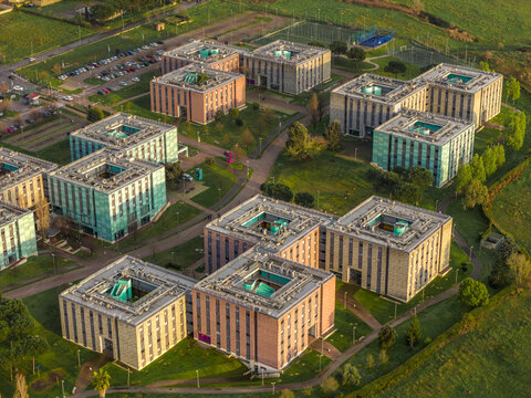 Aerial view of the Tor Vergata University's vibrant, multi-colored buildings nestled amidst green spaces, a structured landscape of learning and leisure, Rome, Lazio, Italy.