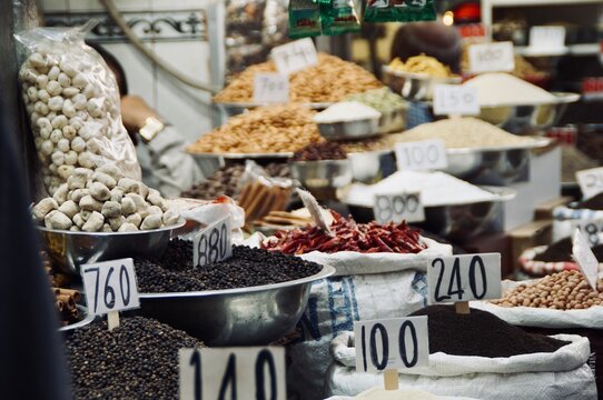 A captivating market scene from Old Delhi's historic Khari Baoli spice market, showcasing traditional Indian pulses, lentils, and spices displayed in metal bowls.          