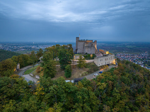 Aerial view of Hambach Castle atop a hill, the historic landmark illuminated against the twilight sky, Neustadt an der Weinstrasse, Rheinland-Pfalz, Germany.