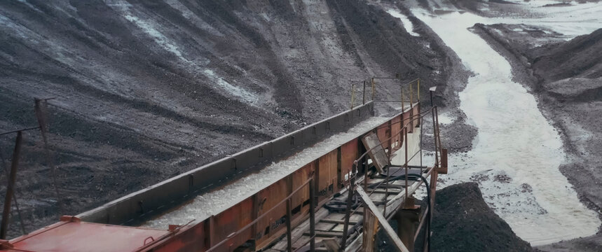 Screen in gold mine with flushing water, draining water into a quarry