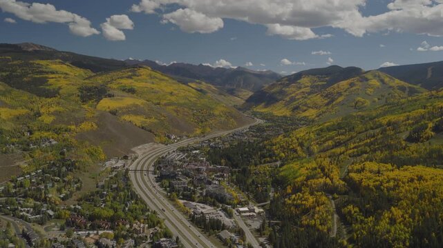 An aerial flyover near Vail, CO with fall colors of Aspen trees and interstate 70