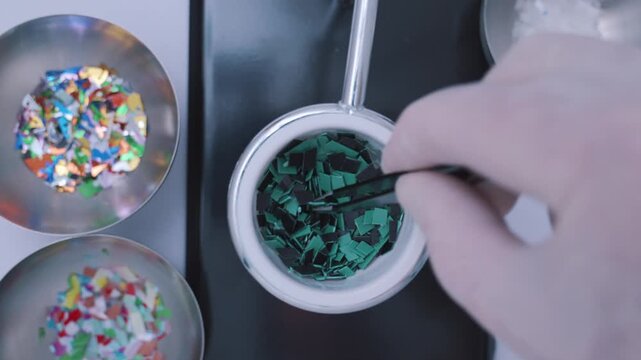 Top down view of a researcher with tweezers selecting microplastic samples for analysis