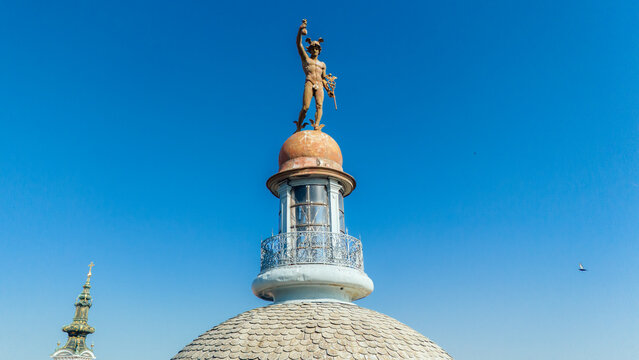 Aerial view of the golden statue atop the building gleams against the azure sky, a beacon of history and art, Novi Sad, Vojvodina, Serbia.